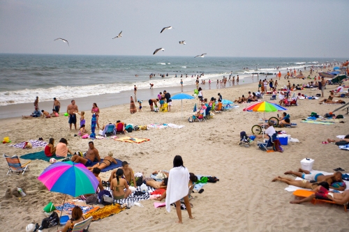 People crowd the beach on a Wednesday afternoon at Rockaway Beach in Queens, New York.